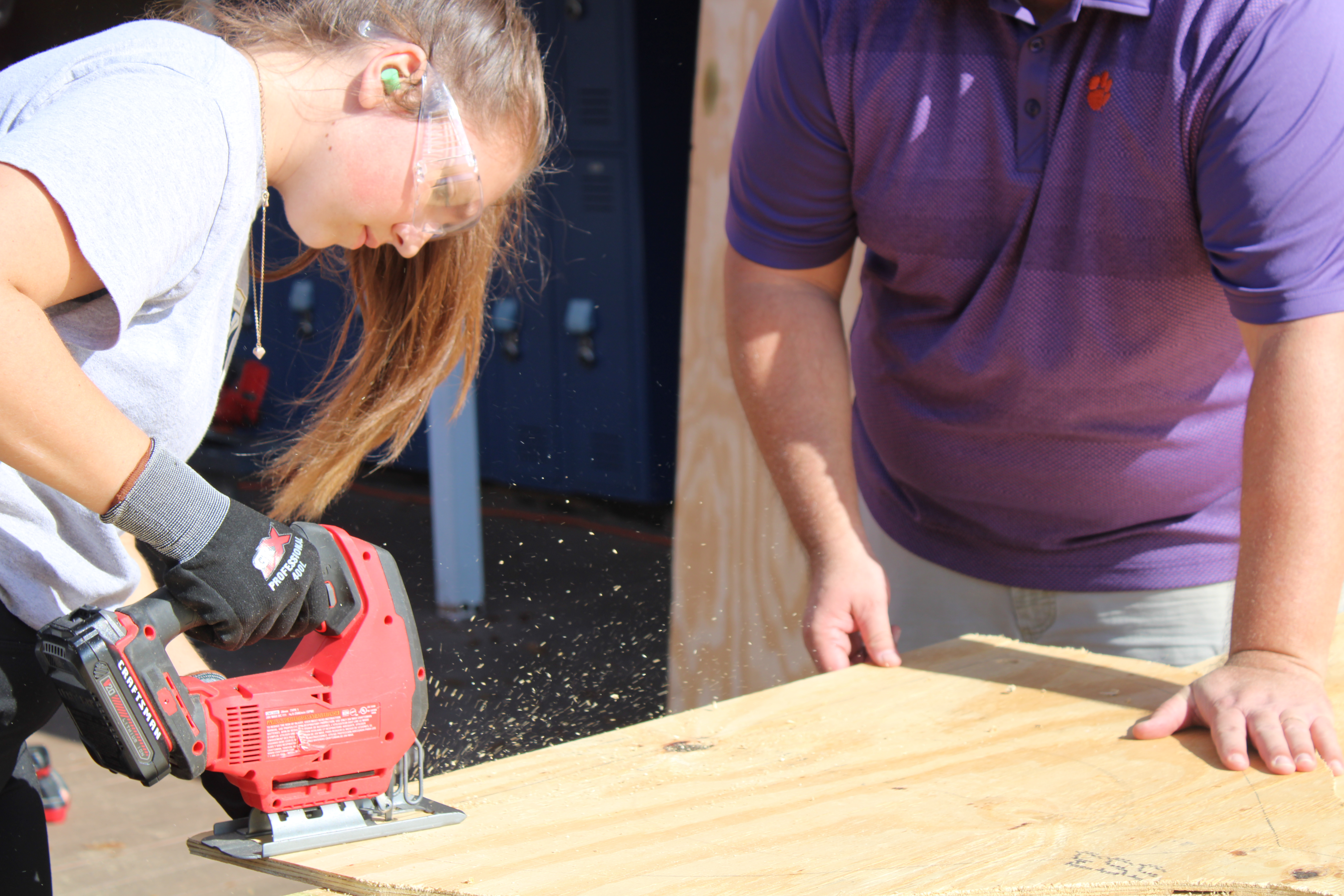 Student uses a jigsaw to cut wood. 