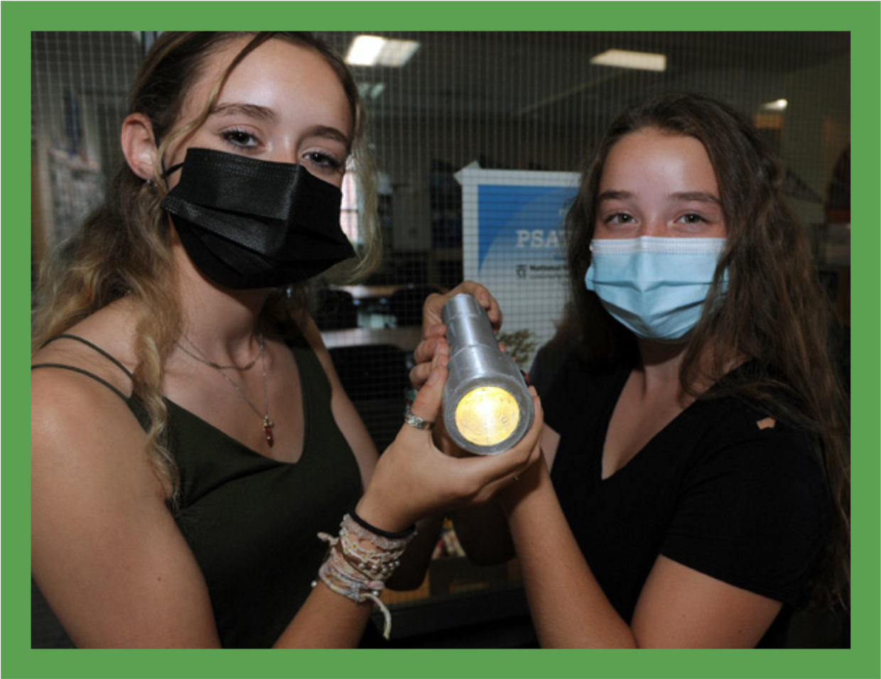 Nicolette and Lauren display their winning invention, Battery Swap, a flashlight that can switch between two battery power sources with a flick of a switch.