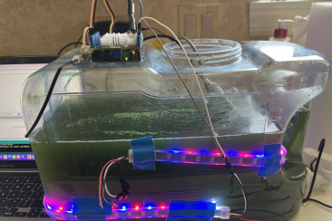 A tank of algae attached to LED lights and various sensors all monitored by a computer