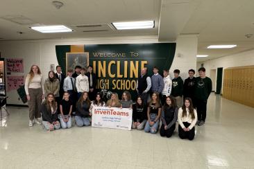 The Incline Village InvenTeam around a sign that says "Welcome to Incline High School". They are holding a poster with the Lemelson-MIT InvenTeams logo on it. 